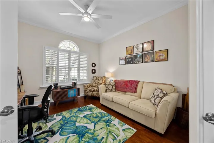 Office featuring crown molding, ceiling fan, and dark wood-type flooring
