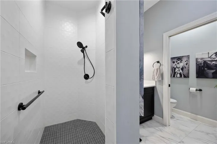Bathroom with vanity, toilet, and a tile shower