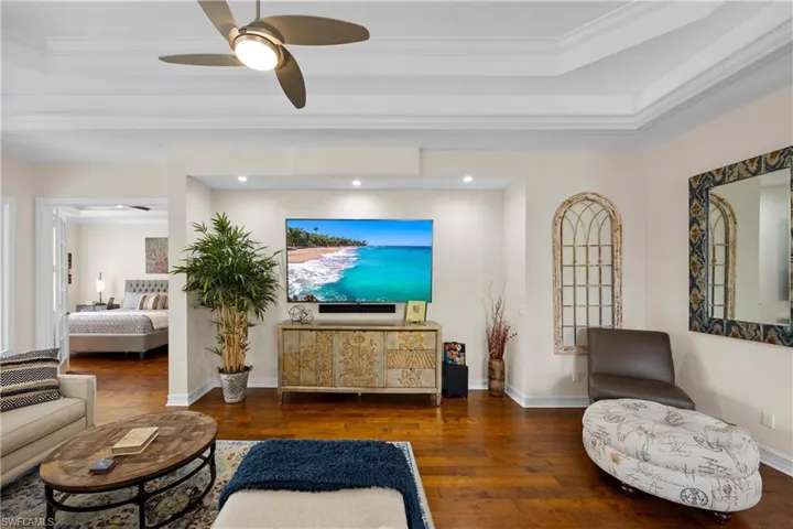 Living room featuring ceiling fan, dark hardwood / wood-style flooring, and ornamental molding