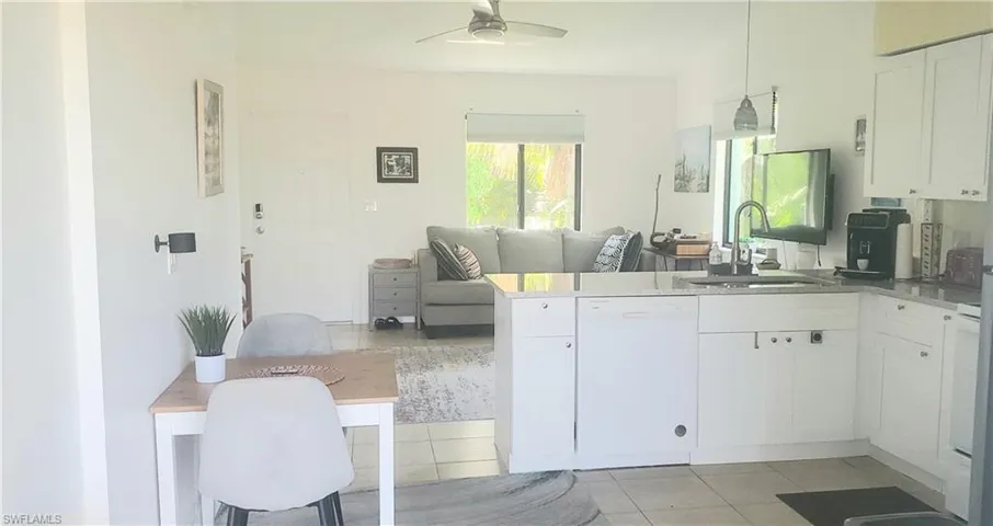 Kitchen featuring white dishwasher, kitchen peninsula, sink, ceiling fan, and white cabinets