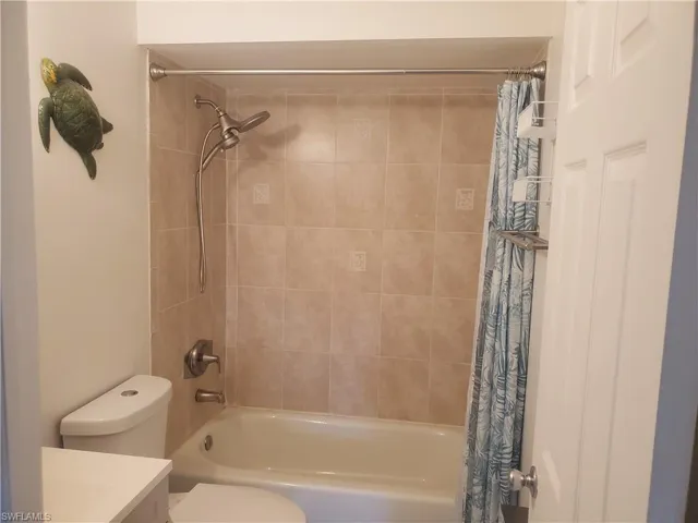 Full bathroom featuring shower / bath combo, vanity, and toilet