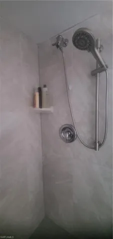 Room details featuring a tile shower
