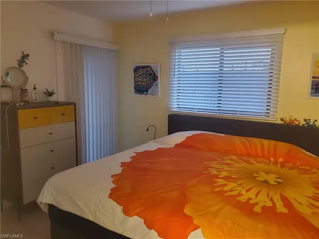 View of bedroom; door exits onto screened balcony