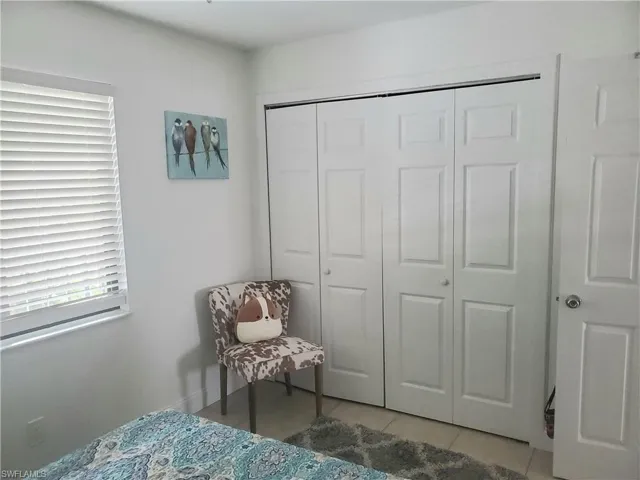 Tiled bedroom featuring a closet