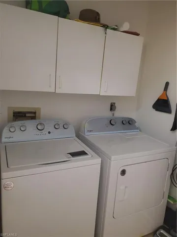 Inside Laundry room featuring cabinets and washing machine and clothes dryer