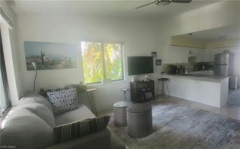 Living room with ceiling fan and light tile patterned floors