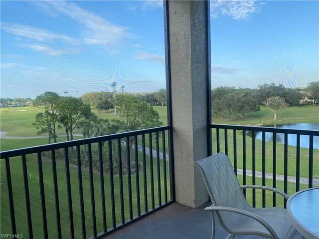 Balcony with a sunroom, view of golf course, and a water view