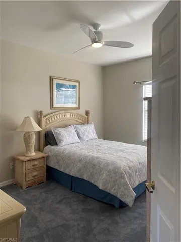 Carpeted bedroom featuring a ceiling fan