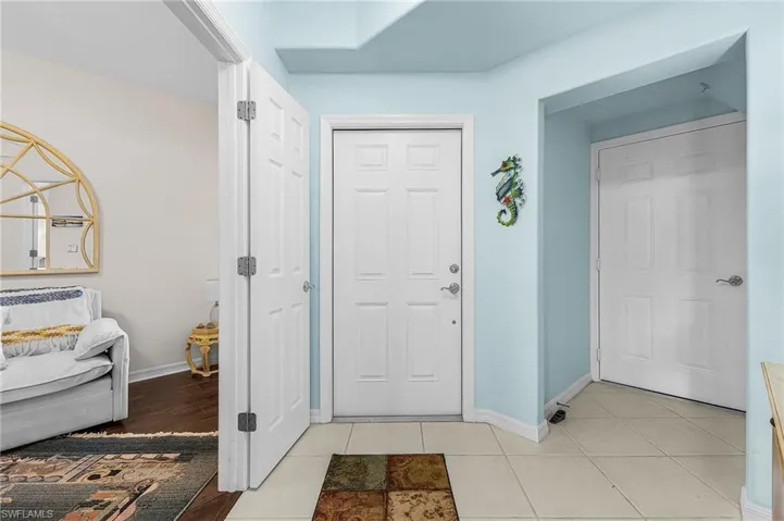 Foyer entrance with baseboards and light tile patterned floors