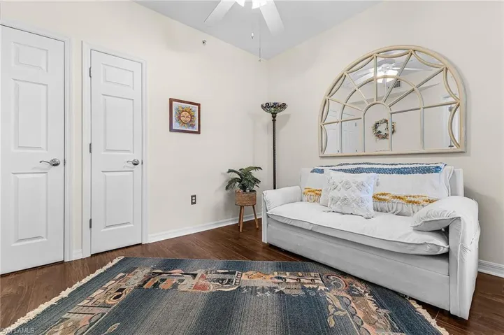 Sitting room with dark wood-style floors and ceiling fan