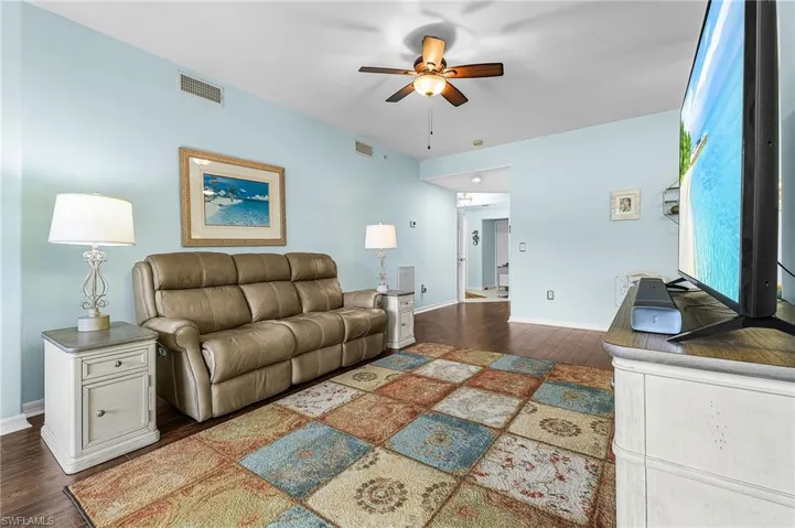 Living area featuring dark wood finished floors and a ceiling fan