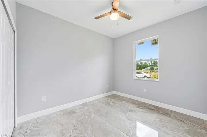 Spare room featuring ceiling fan and light tile floors