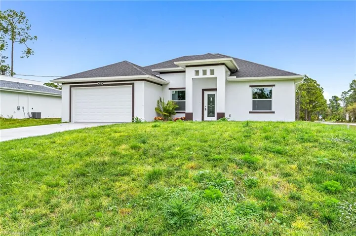 Prairie-style house with a garage, a front yard, and central AC unit