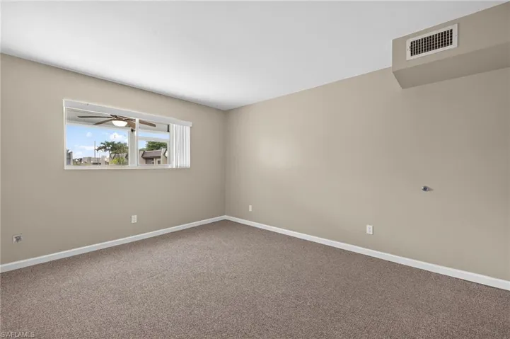 Carpeted spare room featuring baseboards
