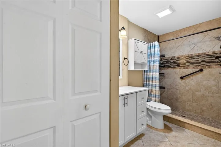 Full bathroom featuring vanity, a shower stall, and light tile patterned floors