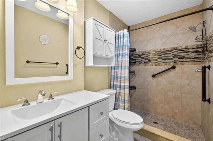 Full bath featuring a stall shower and vanity