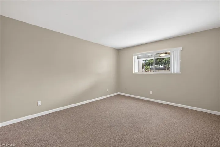 Empty room with baseboards and carpet
