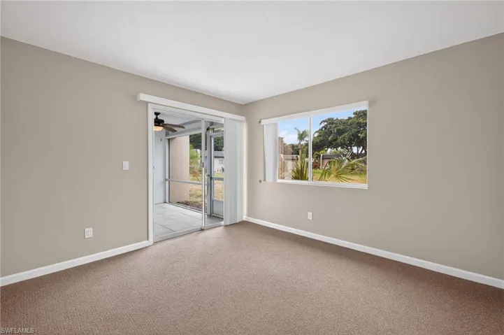 Carpeted spare room with baseboards and ceiling fan
