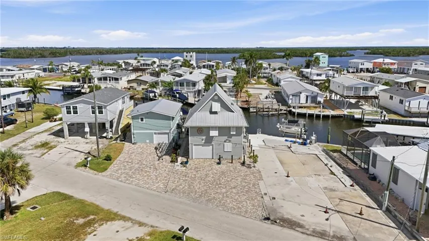 Waterfront property featuring a distinctive light grey exterior with a gabled roofline