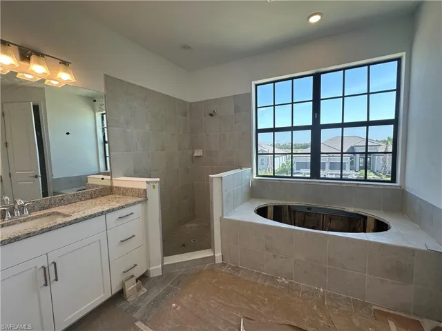 Bathroom with tile floors, independent shower and bath, and vanity