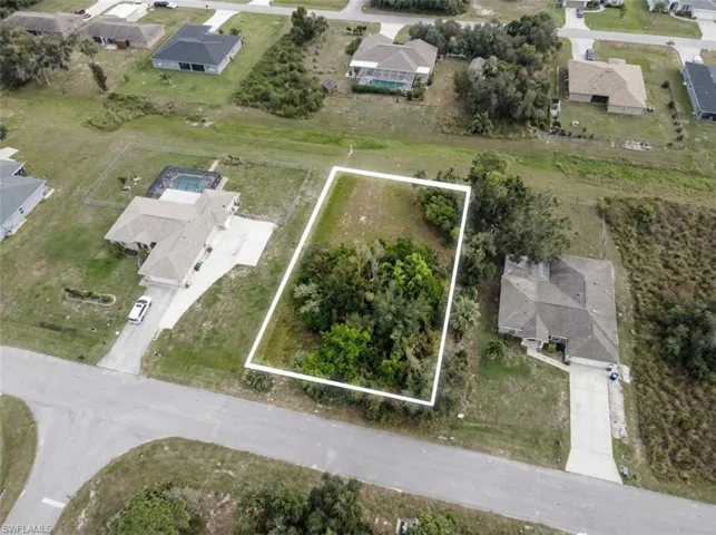 Cleared lot outlined in white, featuring mature trees and natural vegetation