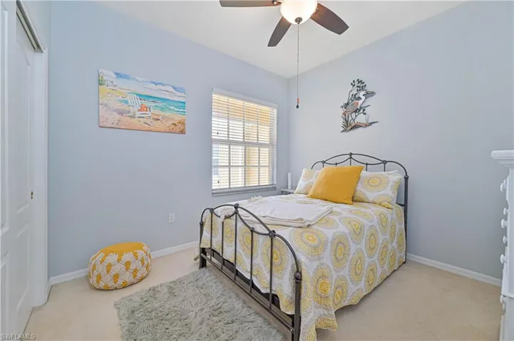 Bedroom featuring a closet, ceiling fan, and light carpet