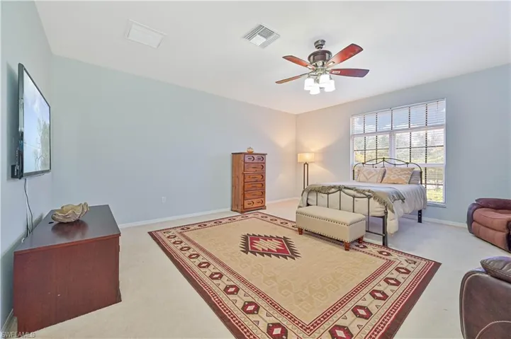 Bedroom with ceiling fan and light colored carpet