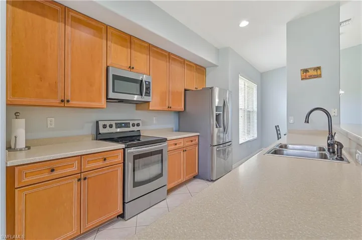 Kitchen with stainless steel appliances, light tile patterned flooring, and recessed lighting