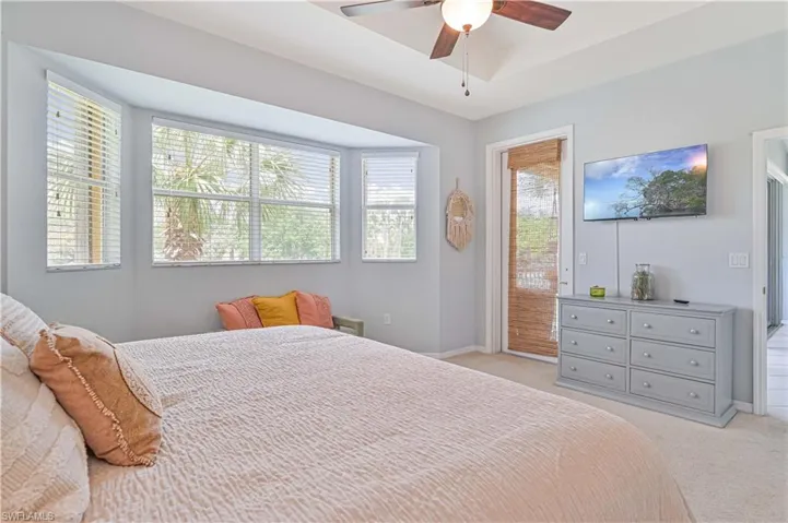 Bedroom featuring access to outside, light colored carpet, and a ceiling fan