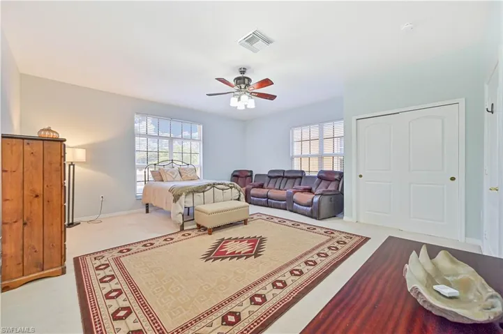 Living room featuring healthy amount of natural light, a ceiling fan, and light carpet