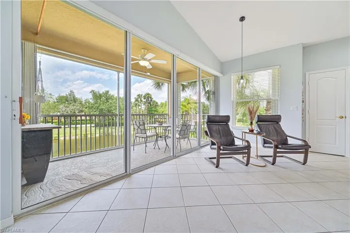 Sunroom with tile patterned flooring and vaulted ceiling
