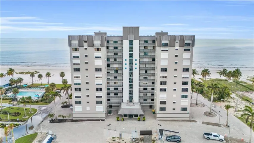 View of building exterior featuring a water view and a pool
