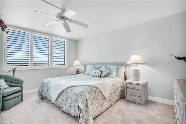 Carpeted bedroom featuring ceiling fan