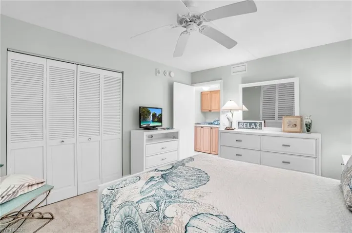 Bedroom with light carpet, a closet, and ceiling fan