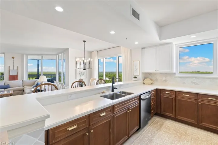 Kitchen featuring a peninsula, backsplash, a chandelier, recessed lighting, and open floor plan