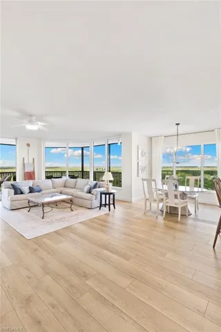 Living area with plenty of natural light, light wood-style floors, and a chandelier