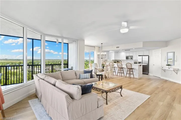 Living area with a chandelier, light wood-style flooring, and ceiling fan
