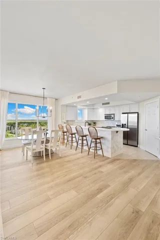 Kitchen with white cabinets, stainless steel appliances, healthy amount of natural light, light wood-type flooring, and recessed lighting