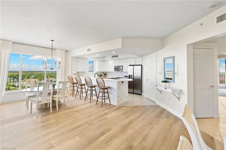 Kitchen with a peninsula, healthy amount of natural light, a chandelier, light countertops, and recessed lighting