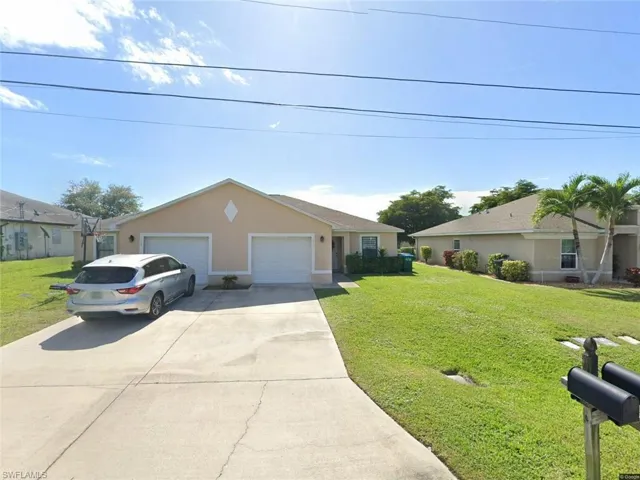 Duplex property with a neutral stucco exterior and shingle roofing