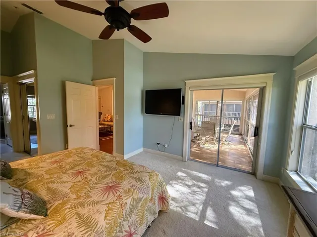 Bedroom with access to exterior, carpet flooring, high vaulted ceiling, and a ceiling fan