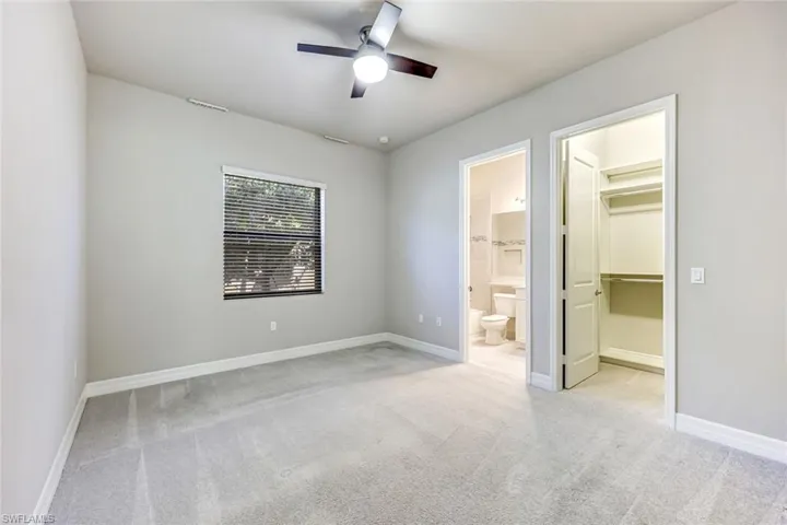 Bedroom with en suite bathroom with vanity, shower / washtub combination and ceiling fan