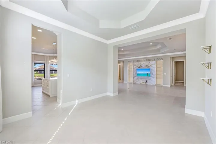 Dining room a tray ceiling, light tile patterned floors, and recessed lighting