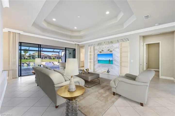 Virtually staged Living area with light tile patterned floors, recessed lighting, a sunroom, and built in shelves