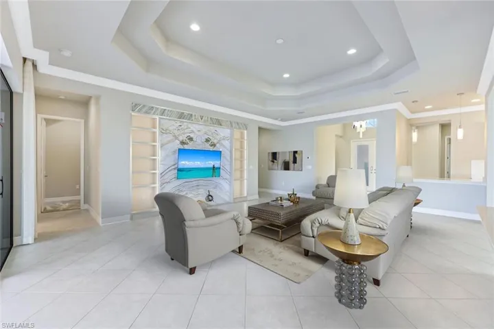Virtually staged Living room with recessed lighting, light tile patterned flooring, a raised ceiling, and french doors