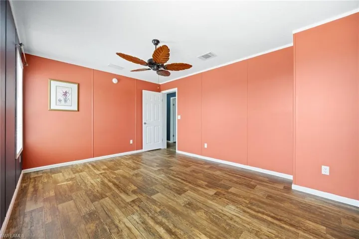 Master bedroom with a tropical ceiling fan and ample light.