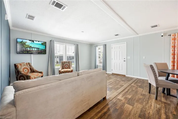 Open concept light and bright living area featuring wood-finish vinyl flooring, and multiple windows.