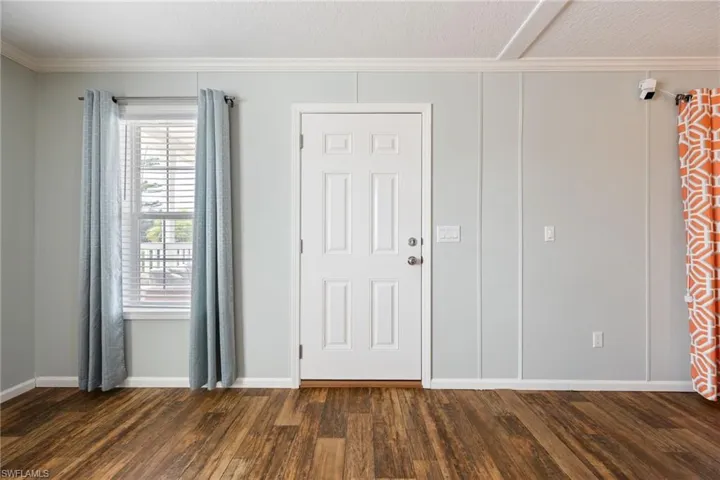Back door leading to the waterfront deck from the living area, wood-finish vinyl flooring.