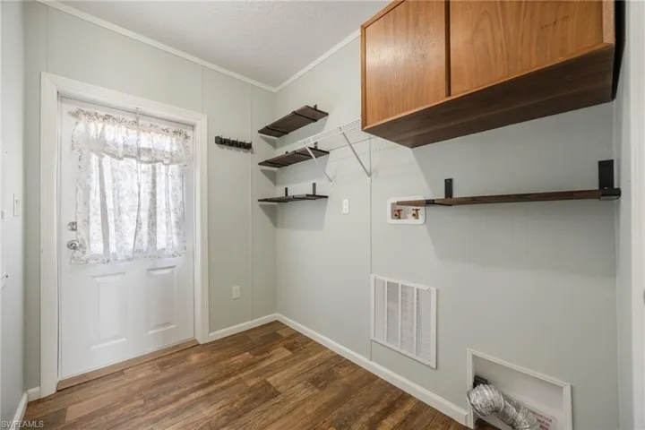 Side entry door leading to laundry area with storage cabinets.