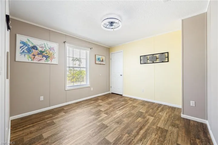 Guest bedroom with a caged ceiling fan, ample lighting, and closet.